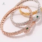 Bijou serpent élégant en or rose, yeux verts scintillants